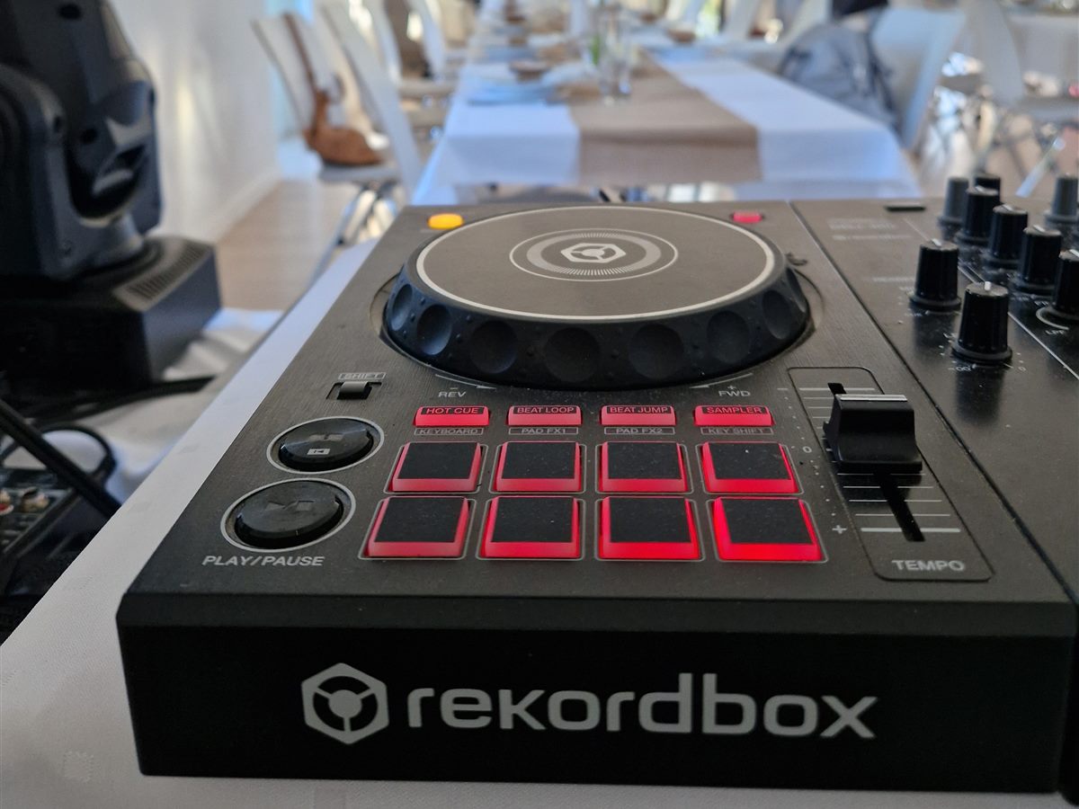 DJ kontroller és mozgófejes lámpa, a háttérben a megterített esküvői ebédlő